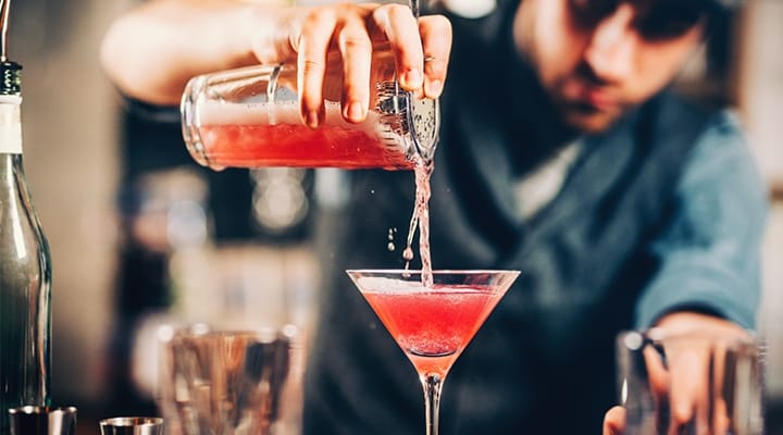 barman pouring red cocktail